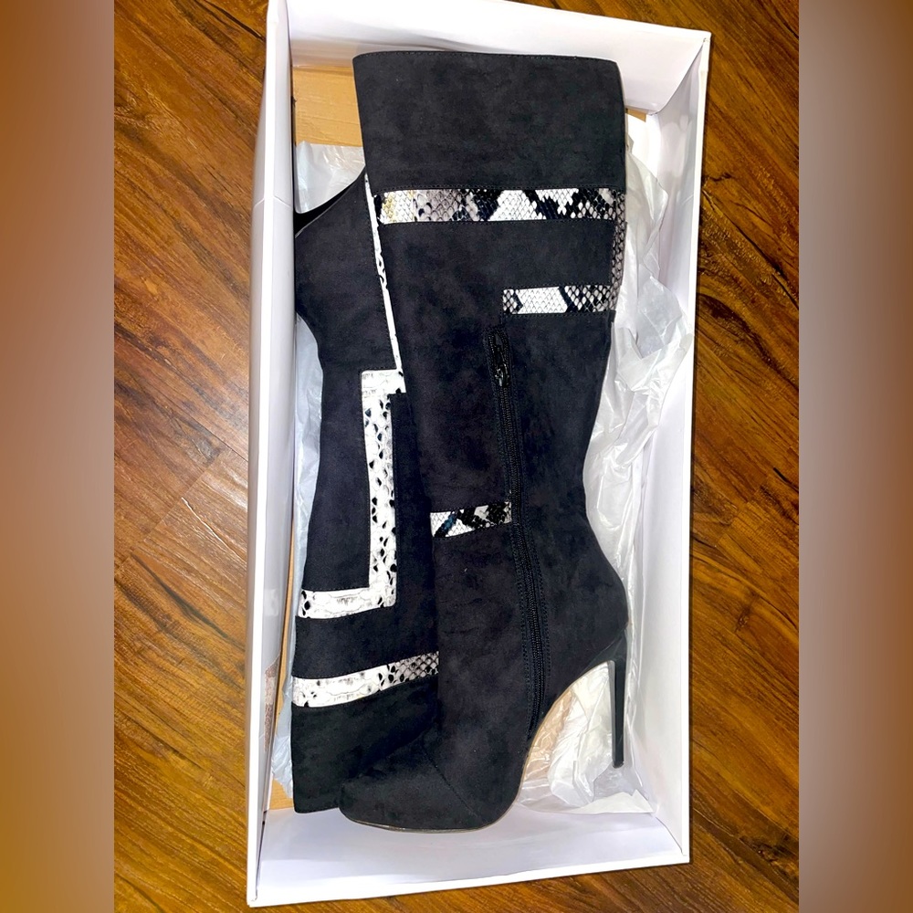 Black knee high stiletto heel boots with snake print design.